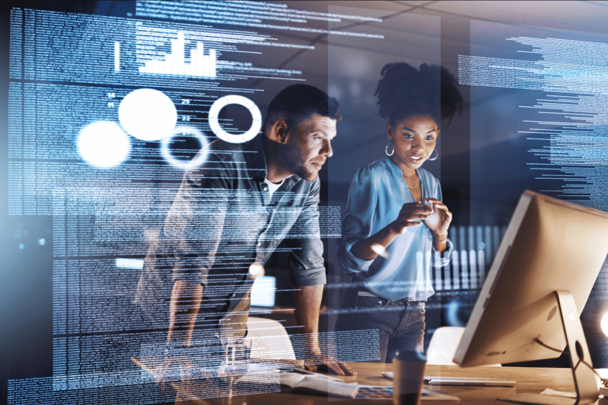 AI managing extensive data using natural language processing and RPA while two people stand in front of a computer in an office watching it in action